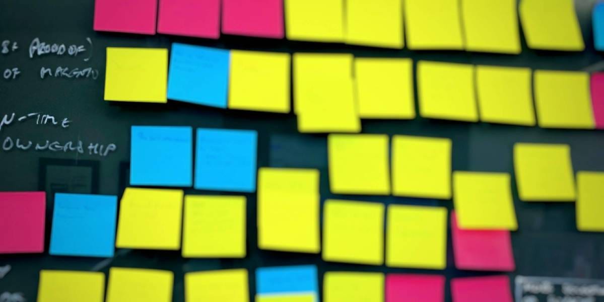 Wall covered in yellow, blue and pink sticky notes during a planning session